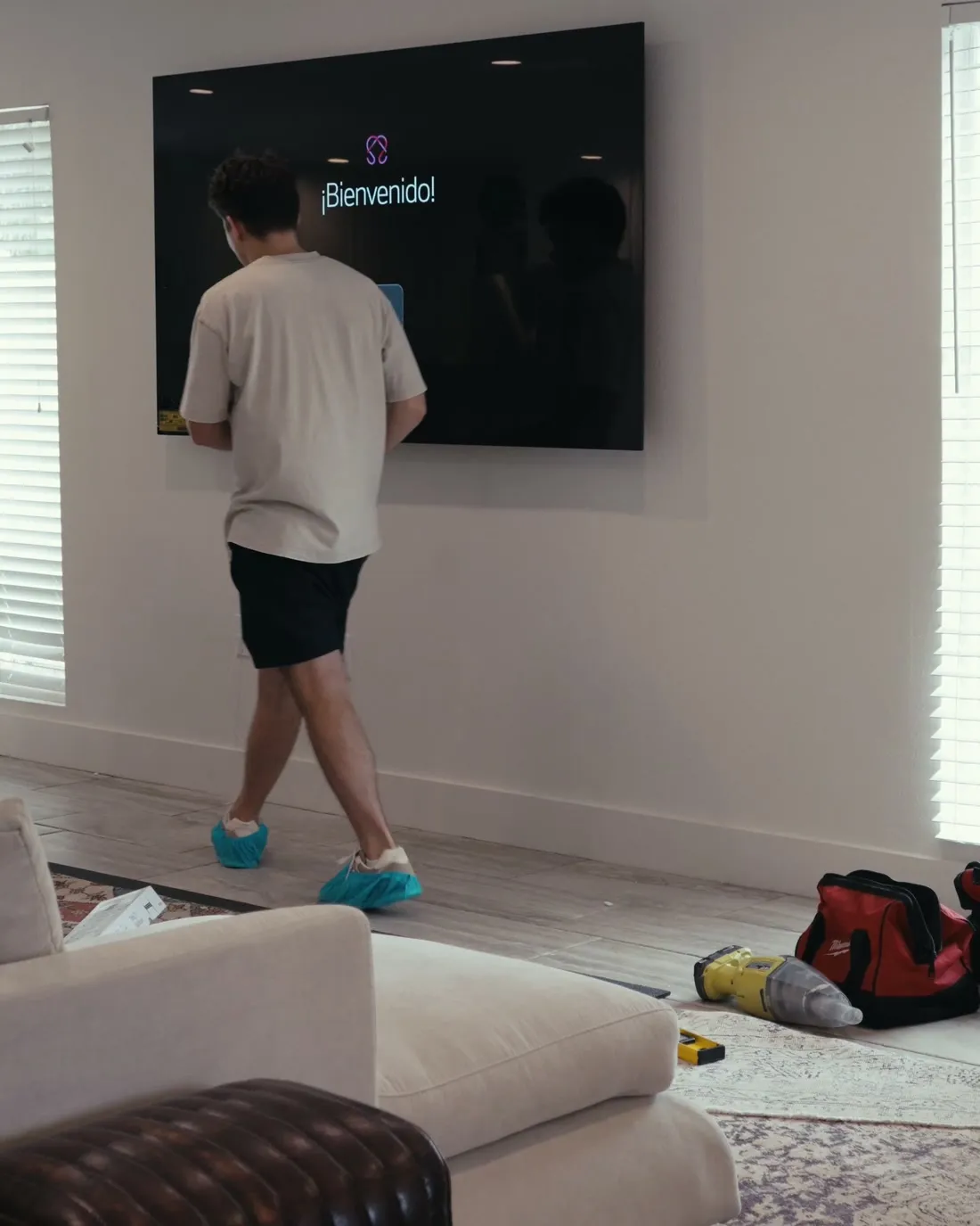 TV Mount Crew installer levelling a wall-mounted TV in a Tampa living room