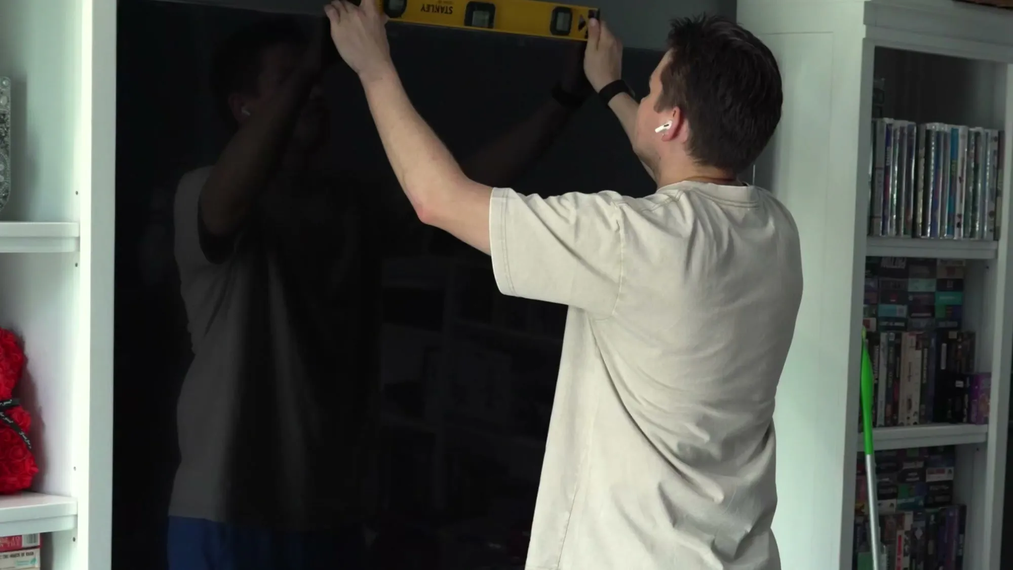 Two installers handling a large TV on the wall