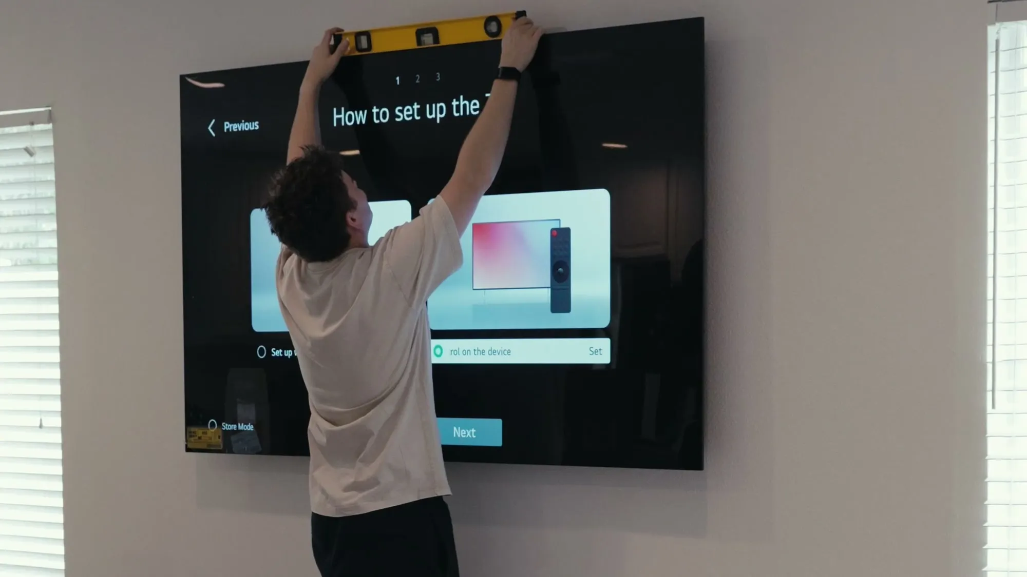 Installer levelling a flush-mounted TV against the wall